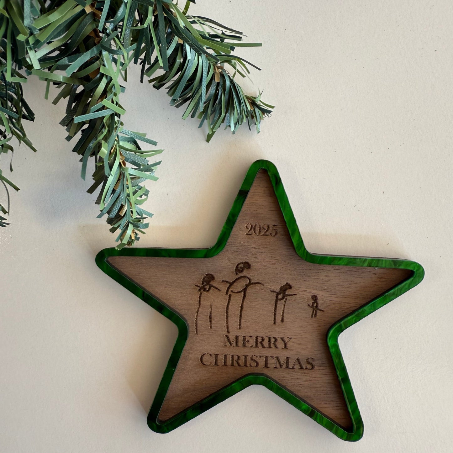 Wooden star ornament with 'Merry Christmas' engraving on a white background