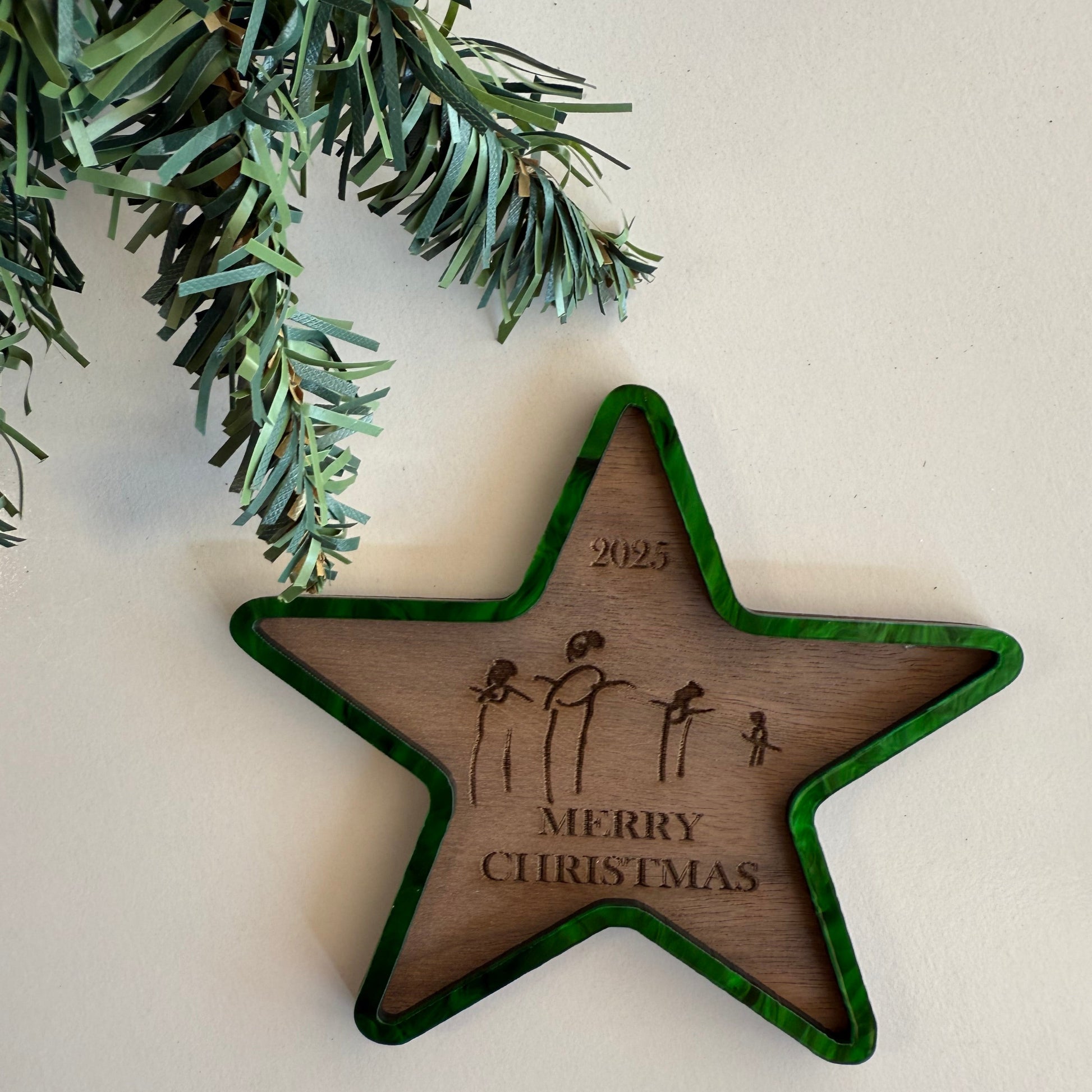 Wooden star ornament with 'Merry Christmas' engraving on a white background